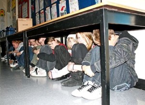 Students hiding under a desk